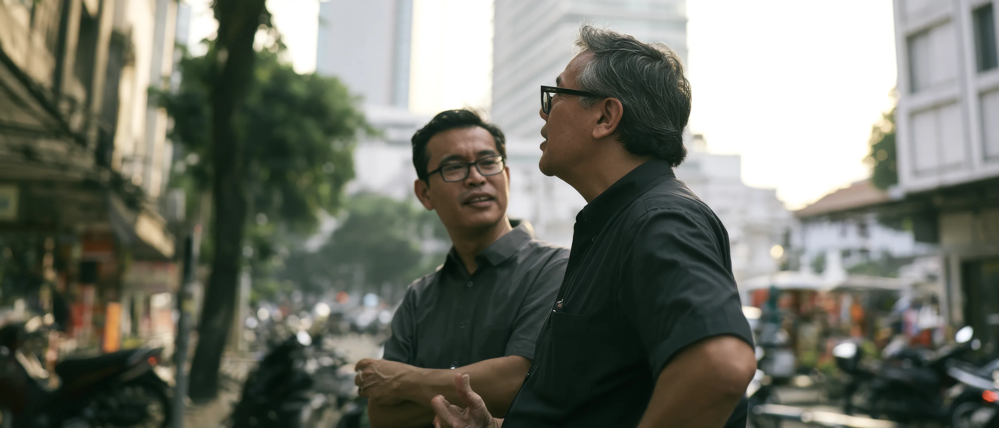 A Singapore enterprise leader walking through an Indonesian commercial district with a local market specialist